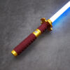 Red and gold katana saber hilt with a glowing white blade on a stone surface.