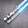 Close-up view of the minimalist silver Snips CW shoto saber hilt, featuring black control buttons and two brass pins, with a vibrant blue electronic blade ignited.