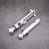 A set of Snips CW primary and shoto saber hilts from Laser Monkey Sabers, displayed together on a concrete surface to show the scale difference between the two silver hilts.