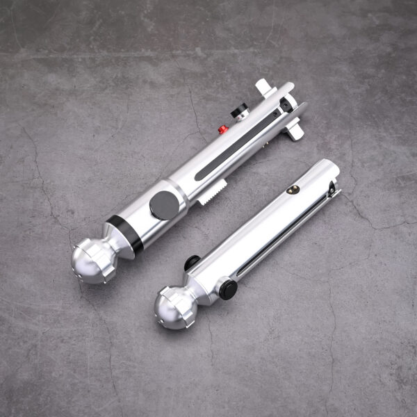 A set of Snips CW primary and shoto saber hilts from Laser Monkey Sabers, displayed together on a concrete surface to show the scale difference between the two silver hilts.